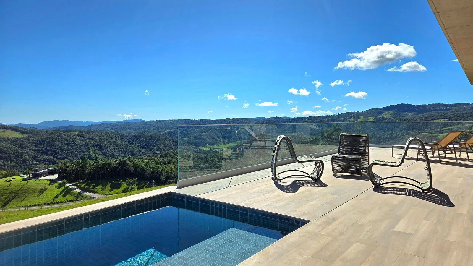 Piscina e deck com espreguiçadeiras