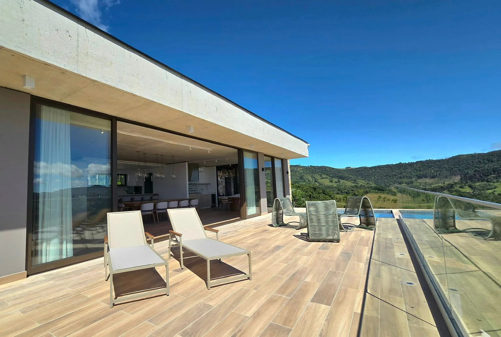 Varanda e piscina da casa em meio à paisagem